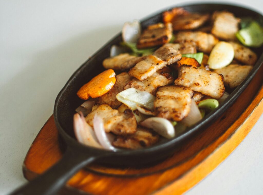 a vegetables with meat cooked in iron griddle